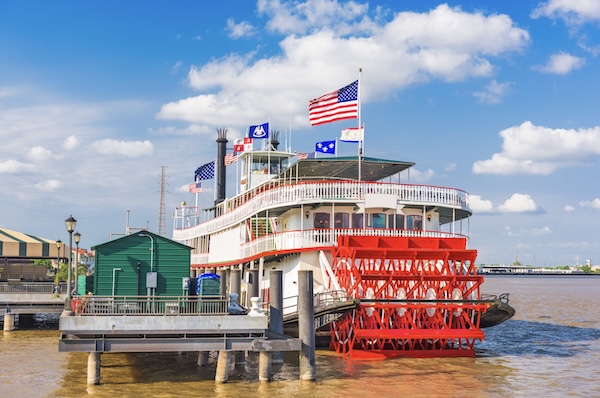 Schaufelraddampfer mit rotem Heckrad am Flussufer in New Orleans