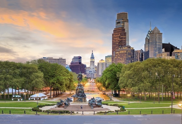 Blick über eine baumgesäumte Prachtstraße auf das Rathaus und die Hochhäuser von Philadelphia