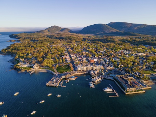 Luftbild von Bar Harbor mit Hafenstegen, Booten und bewaldeten Hügeln im Hintergrund