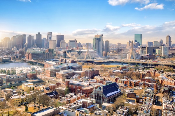 Blick über die Backsteindächer von Boston auf eine Schrägseilbrücke und die Skyline