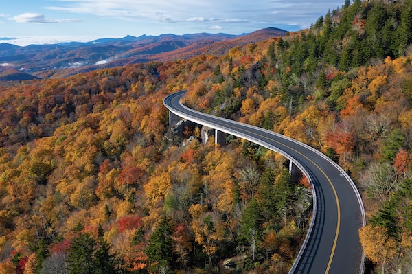 Das geschwungene Viadukt des Blue Ridge Parkway über herbstlich gefärbtem Wald