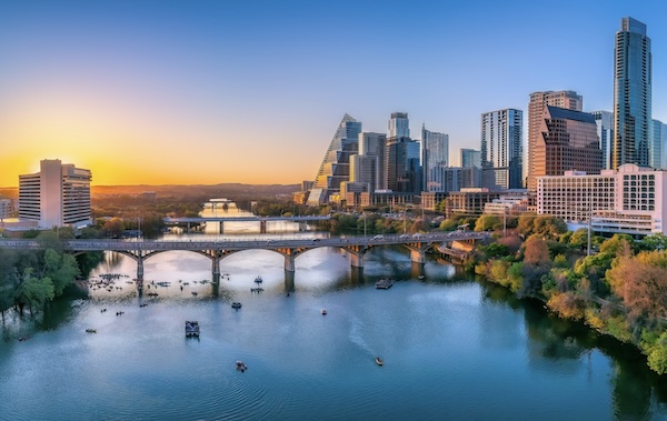 Bogenbrücke über den Fluss in Austin, rechts die Hochhäuser der Innenstadt im Sonnenuntergang