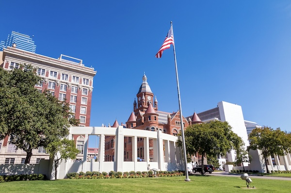 Historisches Gerichtsgebäude aus rotem Sandstein in Dallas, davor eine weiße Kolonnade und die amerikanische Flagge